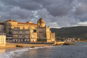 a large castle on the shore of a body of water at Torre Perrotti - Le suite in Santa Maria di Castellabate