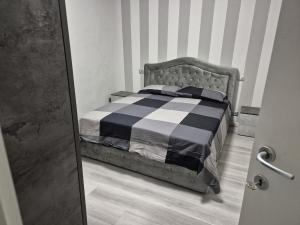 a bed with a black and white comforter in a room at Mia Monza Living in Muggiò
