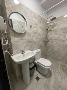 a bathroom with a toilet and a sink and a mirror at Destination Central Room 2 in Tirana