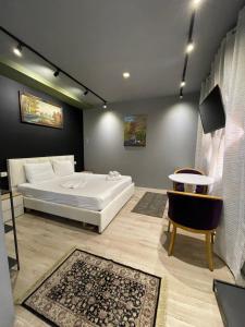 a bedroom with a white bed and a table at Destination Central Room 2 in Tirana