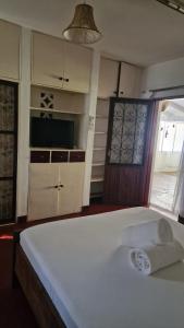 a bedroom with a bed with a towel on it at Boma Banda Diani - Kaskazi Cottage in Diani Beach