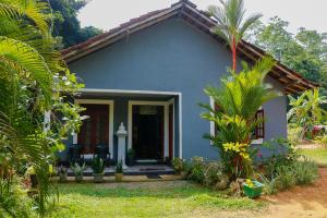 a small house with a blue at Mountain Breeze Inn Midigama in Midigama