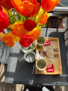 a table with a vase of red and yellow flowers at Luce - Pantano metro C in Osteria dellʼ Osa