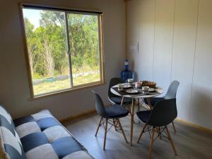 a room with a table and chairs and a window at Cabañas Aurora Castro Quilquico Chiloé in Yutuy