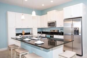 eine Küche mit weißen Schränken und einer schwarzen Arbeitsplatte in der Unterkunft Marvelous 4 Bedroom w/ Pool @ Festival Resort 197 in Davenport + 78 Fotos