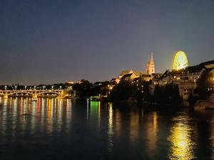 a view of a river with a city at night at Modernes Doppelzimmer nähe Basel in Frenkendorf