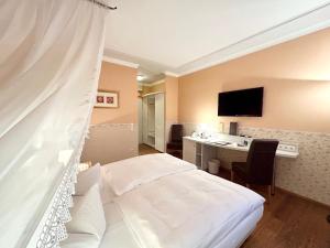 a hotel room with a bed and a desk at Hotel Seehof Leipzig in Zwenkau