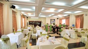 um salão de banquetes com mesas e cadeiras brancas e pessoas em Duy Tan 2 Hotel em Hue