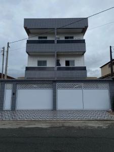 un bâtiment avec deux grandes fenêtres et une clôture dans l'établissement Casa em condomínio 400m da praia, à Praia Grande