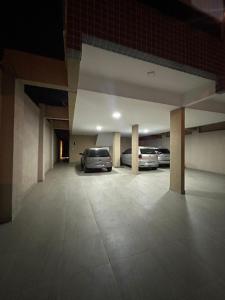 un parking avec deux voitures garées à l'intérieur dans l'établissement Casa em condomínio 400m da praia, à Praia Grande 17 autres photos