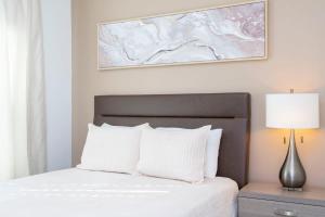 - un lit avec des oreillers blancs et une photo sur le mur dans l'établissement Wonderful 5 Bd Close to Disney @ Storey Lake Resort 2980, à Kissimmee