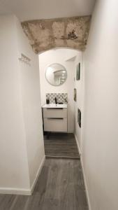 un corridoio con un lavandino in una stanza bianca di Ste Cosy a Istres