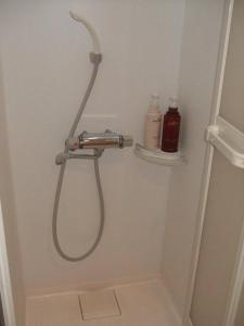 a shower with a blow dryer on a wall in a bathroom at Eco Hotel Nagoya in Nagoya