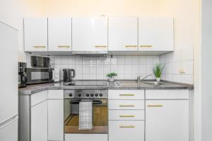 a white kitchen with white cabinets and a sink at Flower Love in Eilenburg +11 photos