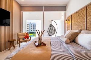 a bedroom with a bed and a chair and a window at Casa Flor Cabo Your Private Oasis in Cabo San Lucas