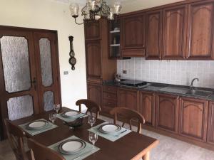 a kitchen with wooden cabinets and a table with chairs at Giardino degli Gnomi in Francavilla al Mare +11 photos