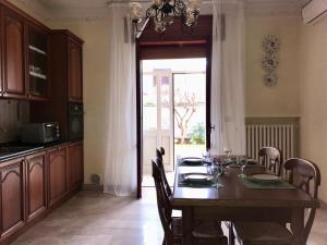 a dining room with a table with chairs and a kitchen at Giardino degli Gnomi in Francavilla al Mare