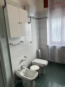 a white bathroom with a toilet and a sink at Giardino degli Gnomi in Francavilla al Mare