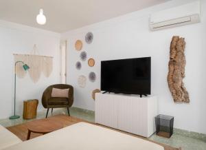 a living room with a flat screen tv on a white cabinet at Ocean View Retreat 2 - Sea View with Jacuzzi in São Roque