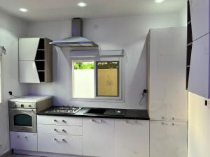a white kitchen with a stove and a window at Darou Salam in Ndangane