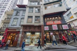 um grupo de pessoas atravessando uma rua em frente a uma loja em Hotel Madera Hollywood em Hong Kong