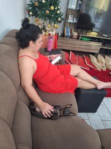 a woman in a red dress sitting on a couch at Pousada Hotel Araguaia in Aragarças
