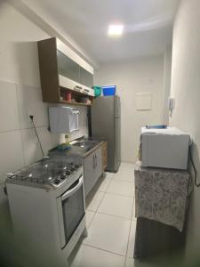 een keuken met een fornuis en een koelkast bij Apartamento Vog Atlântico in Ilhéus