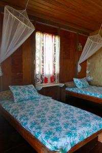 una camera da letto con due letti e una finestra di Big Sky Lodge a Crochu