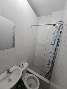 a white bathroom with a toilet and a sink at HOSPEDAJE ALVARADO - Matrimonial - 103 - Bueno Bonito y Barato in Cajamarca