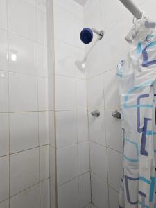 a bathroom with a shower with white tiles at HOSPEDAJE ALVARADO - Matrimonial - 103 - Bueno Bonito y Barato in Cajamarca +3 photos