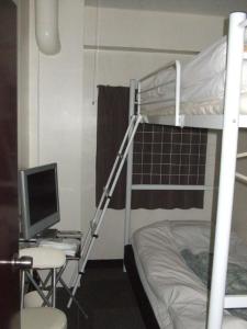 a bedroom with a bunk bed with a computer and a desk at Eco Hotel Nagoya in Nagoya