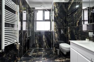 a black bathroom with a toilet and a sink at Pop Up Aparthotel in Bucharest