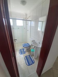 a bathroom with a toilet and a sink at Ap frente pro mar bloco - 2 in Mongaguá