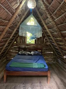 een bed in een houten zolderkamer bij Cabana Juriti in Camaçari