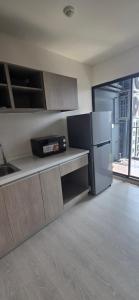 a kitchen with a stainless steel refrigerator in a room at Grene Donmueng in Thung Si Kan