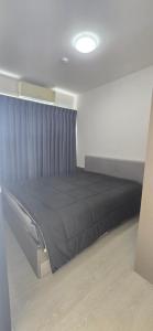 a bedroom with a black bed in a room at Grene Donmueng in Thung Si Kan +1 photo