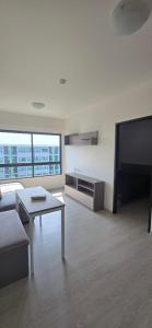 a living room with a couch and a table and a tv at Grene Donmueng in Thung Si Kan