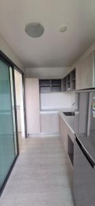 an empty room with a kitchen with a large window at Grene Donmueng in Thung Si Kan