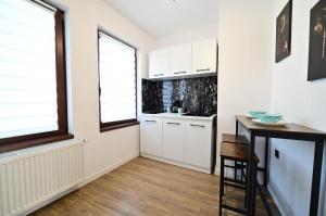 cocina con armarios blancos, mesa y ventana en Old Town Ruby, en Sibiu