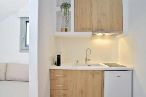 a kitchen with wooden cabinets and a sink at Niriis Studios Aktaia & Glauke Batsi in Batsi +27 photos
