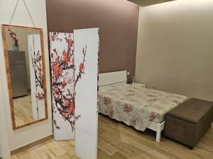 a small bedroom with a bed and a mirror at Casa Melograno in Bernalda