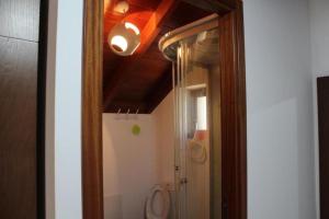 a bathroom with a toilet and a light on the ceiling at Zef's Cottage in São Vicente +28 photos
