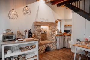 a kitchen with a stone fireplace and a table at ILLASI DREAM ROOMS in Illasi
