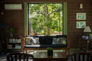 ein Wohnzimmer mit einem Sofa und einem Fenster in der Unterkunft Neem Tree House in Kirinda