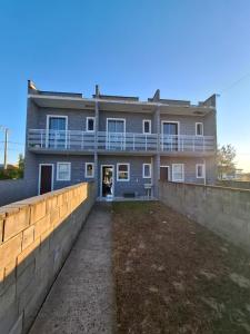 una casa con un muro di contenimento davanti di S2 - Residencial Soulmar Balneário Gaivota - SC - Village Dunas Norte - 1,5 quadra do mar a Balneário Gaivotas