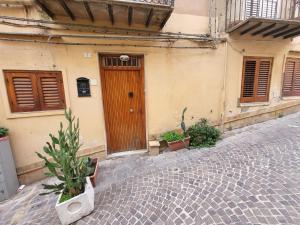 un edificio con una porta in legno su una strada di ciottoli di Al Dammuso Diffuso in Centro a Agrigento