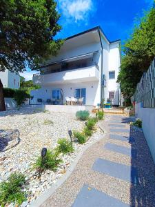 a white house with a walkway in front of it at Meraki Apartment Kostrena two bedrooms in Kostrena