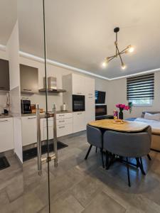 a kitchen and living room with a table and a couch at Meraki Apartment Kostrena two bedrooms in Kostrena