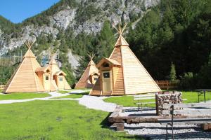 a group of tents in a field with a mountain at Tipi Dorf Gröbming in Gröbming