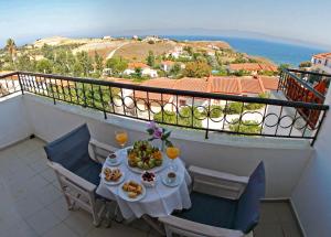 a table with food and drinks on a balcony at Belvedere Aeolis Hotel in Mythimna